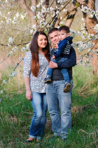 Ritratto di famiglia all'aperto in giardino primaverile fiorito — Foto Stock