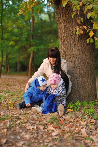 Daughter, son and mother in the autumn park — Stock Photo, Image