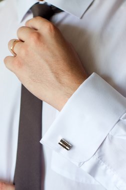 Kol düğmeleri ile Beyaz gömlekli adam, kravatını düzeltiyor