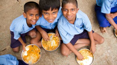Hint devlet okulu öğrencileri üniformalarını giyip Hindistan 'daki bir devlet okulunda bedava öğle yemeğinin keyfini çıkarıyorlar. Hindistan 'daki okullarında öğle yemeği yiyen devlet okulu çocukları..