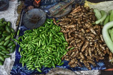 Bir sebze satıcısı Hint sokak pazarında farklı türde sebze satar.