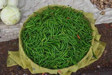 Taze yeşil, lezzetli biberler sepetin içinde Hint sokak pazarında satılacak.