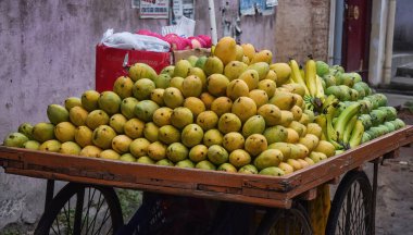 Hint sokak pazarında satmak için sepetin içinde taze lezzetli ve sulu mangolar ve muzlar.  