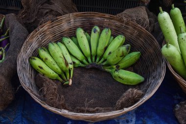 Hint sokak pazarında satılması planlanan sepette taze yeşil çiğ muz.