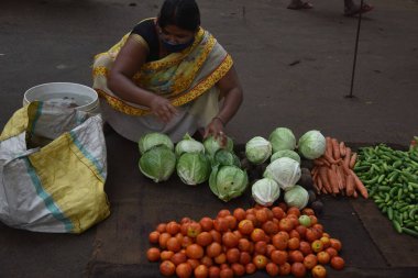 Sebze, lahana, domates, havyar satan bir kadın Hindistan 'daki sokak pazarında satışı ayarlanmış.. 