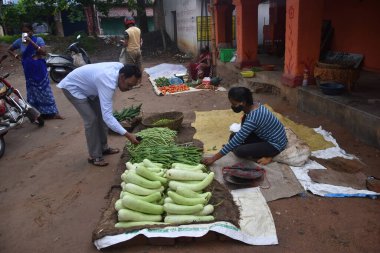 Hint erkek çiftçi görüntüsü sebze (şişe kabağı, daha iyi bilinen adıyla bamya), Hint sokak pazarındaki Mandi adlı diğer erkeğe sünger kabağı ve biber satışı.