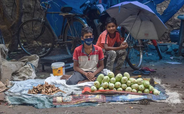 2人の子供がインドのストリートマーケットでマンゴー アンディ アルビの根を売っています — ストック写真
