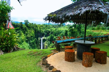 Okyanusya 'daki renkli tropik cennet bahçesi, palmiye saplı ahşap barınak orman gözcüsü, Samoa, Upolu Adası' ndaki Sopoaga Şelalesi tatil köyü.