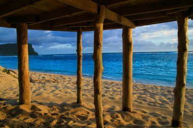 Deep blue waters of Pacific Ocean wiev through wooden pillars of beach fale - traditional Samoan house Lalomanu beach Samoa, Polynesia clipart