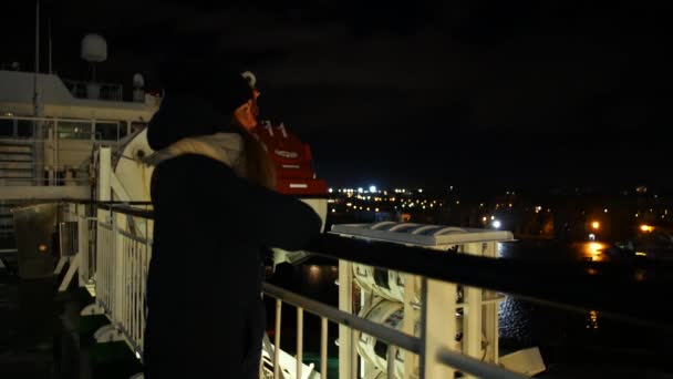 若い女性は、フェリーの航海中に街に別れを言う — ストック動画