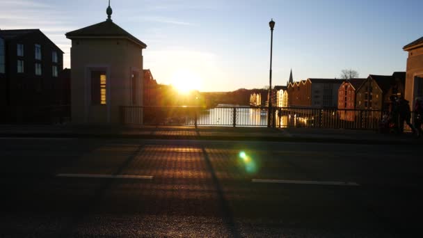 Familie im Sonnenlicht auf Brücke in der Nähe berühmter Holzhäuser in der Stadt Trondheim, Norwegen — Stockvideo