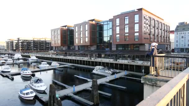 Mujer mirando la vista de invierno de un puerto deportivo en Trondheim — Vídeos de Stock