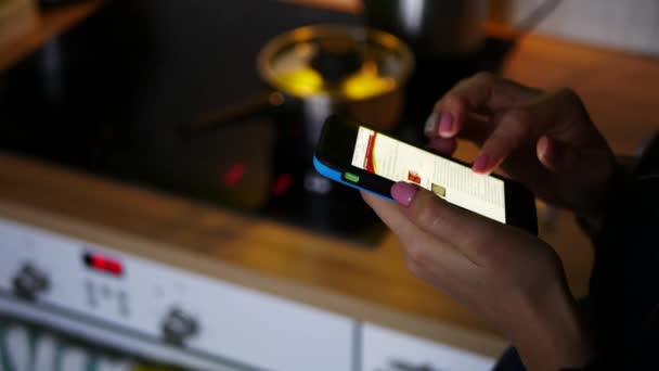 Mão feminina usando smartphone na cozinha, tiro de mão — Vídeo de Stock