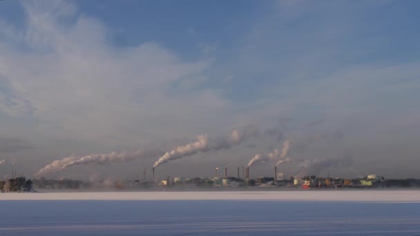 Завод с выдувающим дымом из трубы возле озера, Финляндия, экология ЕС — стоковое видео