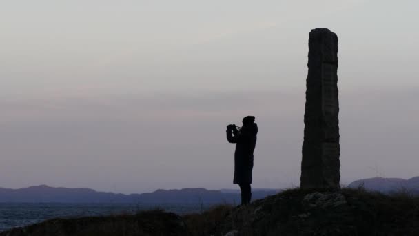 Reizen concept - toeristische nemen foto van fjord in Noorwegen in avond op camera — Stockvideo