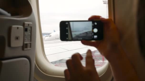 Ung kvinna ta bilder på hennes smarta telefonen före flygning — Stockvideo