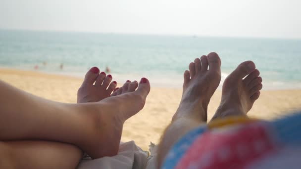 Tan Pies de una pareja en sillones disfrutando de unas vacaciones en la playa — Vídeos de Stock