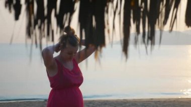Gün batımında sahilde poz uzun saçlı baştan çıkarıcı hamile kız