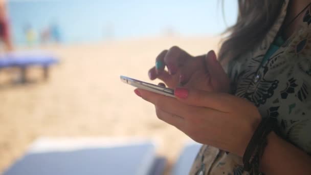 Jovem mulher usando celular na praia, tiro Handheld — Vídeo de Stock