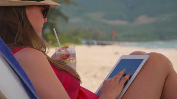 Γυναίκα χρησιμοποιώντας υπολογιστή tablet στην παραλία — Αρχείο Βίντεο