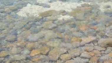Taşların altında sallanan deniz suyu