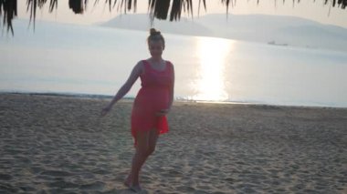 Hamile kadın zevk staing Beach günbatımı zaman mutlu gülümseyerek. Vietnam tropikal tatil.