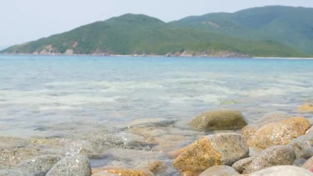 Pietre sotto l'acqua del mare che ondeggia, isola tropicale sullo sfondo 4k uhd 2160p — Video Stock