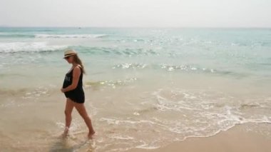 Sahilde bekleyen anne. Deniz kıyısı yürüyen hamile kadın