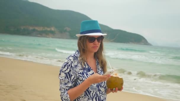 Mujer feliz usando un teléfono inteligente en la playa, mar en el fondo, disparo steadicam — Vídeos de Stock