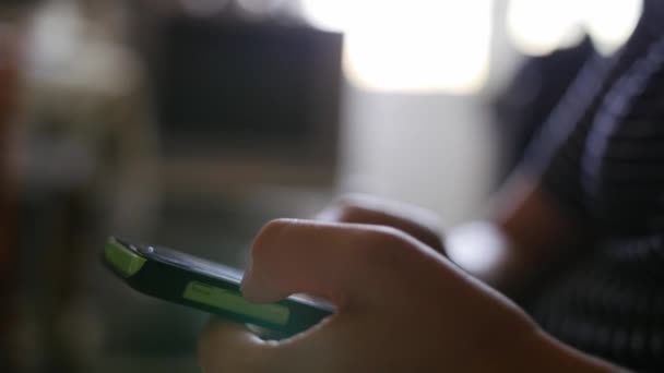 Feche as mãos de um homem usando o telefone touchscreen verde — Vídeo de Stock