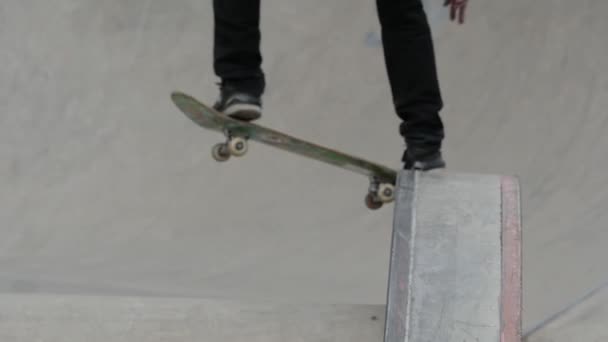 Vista borrosa de un joven saltando desde la cornisa en el parque de skate — Vídeos de Stock
