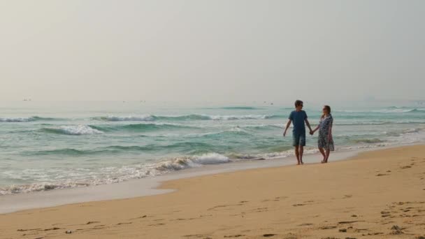 Attraktiva kaukasisk par gå genom stranden på tropisk ö, 4 k uhd 2160p — Stockvideo