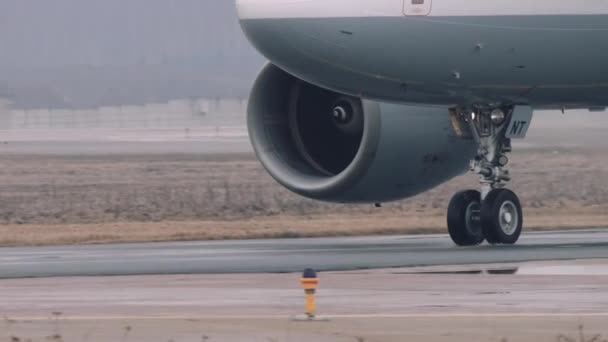 Wielen en turbines van een airbus a319-100 verplaatsen op een baan in de luchthaven. Close-up beeld, mist weer, 4 k Uhd 2160 p — Stockvideo