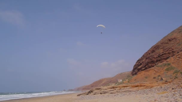 Paraglider vliegen boven strand — Stockvideo