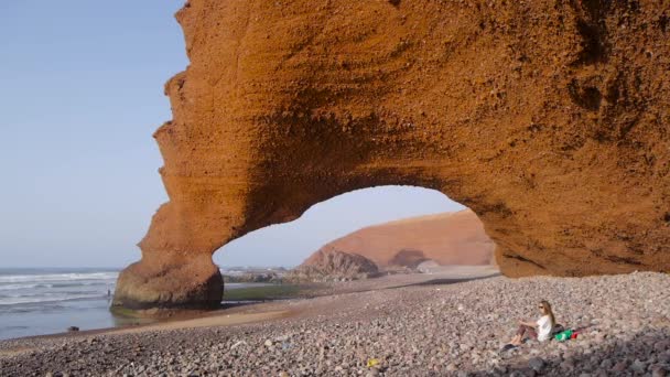 Chica relajante en la playa de Legzira, Marruecos — Vídeo de stock