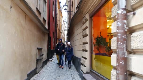 Dois casal andando de mãos dadas na cidade de Estocolmo, Suécia, Europa. feliz jovem casal andando fora em Stortorget grande praça em Gamla Stan, a cidade velha — Vídeo de Stock