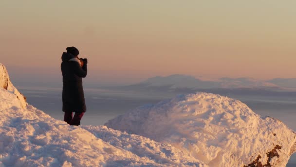 Жінка, спостерігаючи Схід сонця від верхньої частини гори є, Швеція і фотографувати відкривається прекрасна панорама — стокове відео