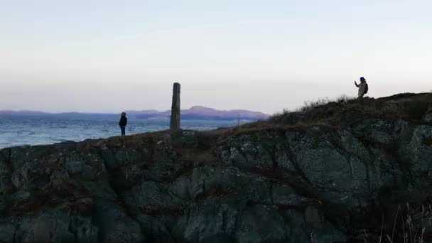 Jeunes mariés vacances de lune de miel en Norvège. Homme prenant une photo de femme près du fjord — Video