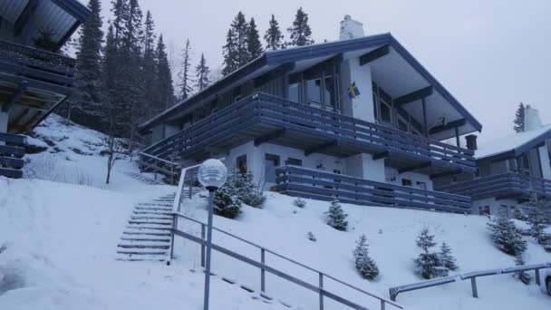 La neve cade su una casa a due piani nella foresta invernale, Svezia — Video Stock