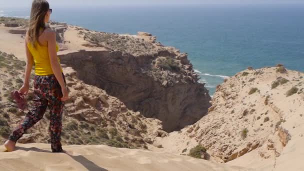 Ragazza croce deserto, splendido sfondo mare con rocce — Video Stock