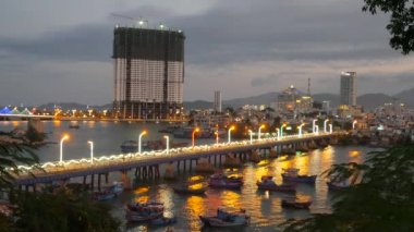 Trafik bir gece köprü olarak pek çok motosiklet. Şehir koyu mavi deniz araçları ve Binalar içinde belgili tanımlık geçmiş. Nha Trang, Vietnam.