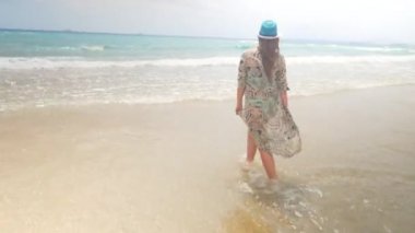 Deniz dalgaları aracılığıyla gidiş ve rüzgar ile oynarken çekici hamile kadın.