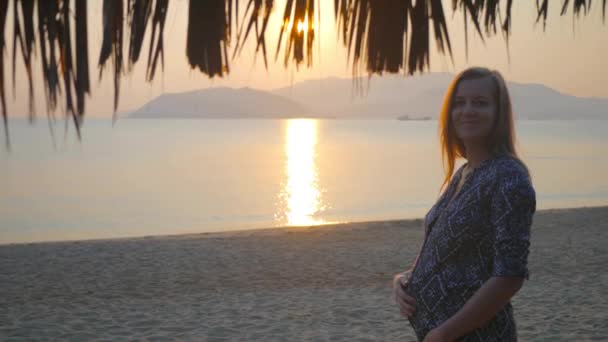 Prety donna incinta millenaria accarezzando pancia e posa al tramonto sulla spiaggia. Vacanza tropicale in Vietnam, 4k uhd 2160p — Video Stock