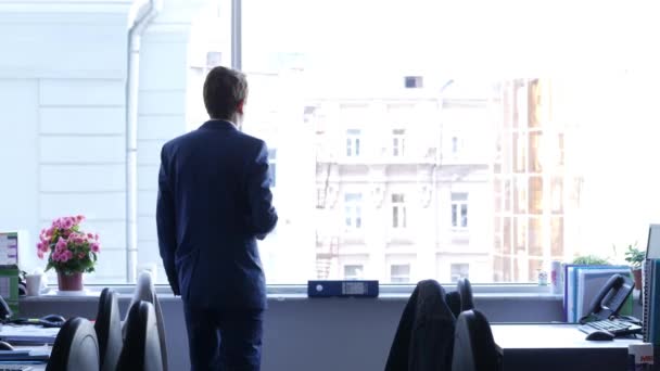 Um homem de negócios com café pensando e olha pela janela de uma forma contemplativa, 4k UHD 2160p, dolly slider shot — Vídeo de Stock