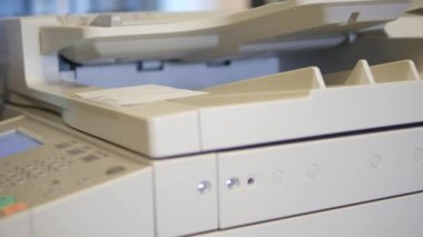 Bir office copier kapağını açarak ve bir kopya yapmak için bir belge koyarak bir adam. Dolly vurdu