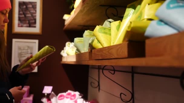 Attraktive junge Frau bei der Auswahl von Süßigkeiten im Schokoladenladen in Stockholm, Schweden — Stockvideo