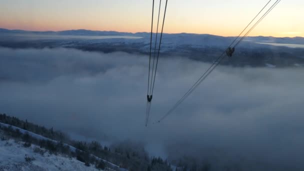 Vue depuis la cabine mobile sur la tour de téléphérique et le soleil couchant. Suède — Video