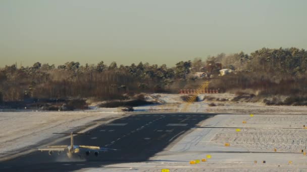 Airplaine in winter airport moving on a runway after landing and turning rigth to a taxiway. Heat haze over the plane — Stock Video