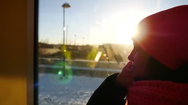 Fundersam ung kvinna ridande spårvagnen i sunflare solljus, steadicam sköt — Stockvideo