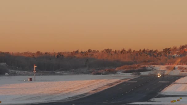 Vliegtuig opstijgt besneeuwde luchthaven in Zweden. Prachtige vroege moning licht — Stockvideo